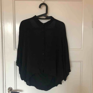  - Svart skjorta i oversize med hål i ryggen 