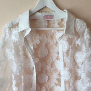  - En blommig transparent blus med knappar. Aldrig använd bara provat! 😊
