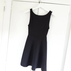  - Svart enkel klänning med v-ringad rygg och stretch material 