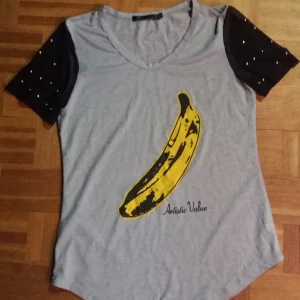  - Oanvänd tshit. Mesh-ärmar med nitar på. Stl M.