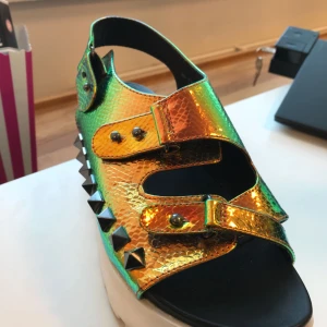  - Härliga platå sandaler med oljeeffekt och studs på. Sparsamt använda. Det är lite reglerbara med spännen runt foten, därför kan den passa både 37:or och 38:or. Om skorna postas tillkommer frakt.