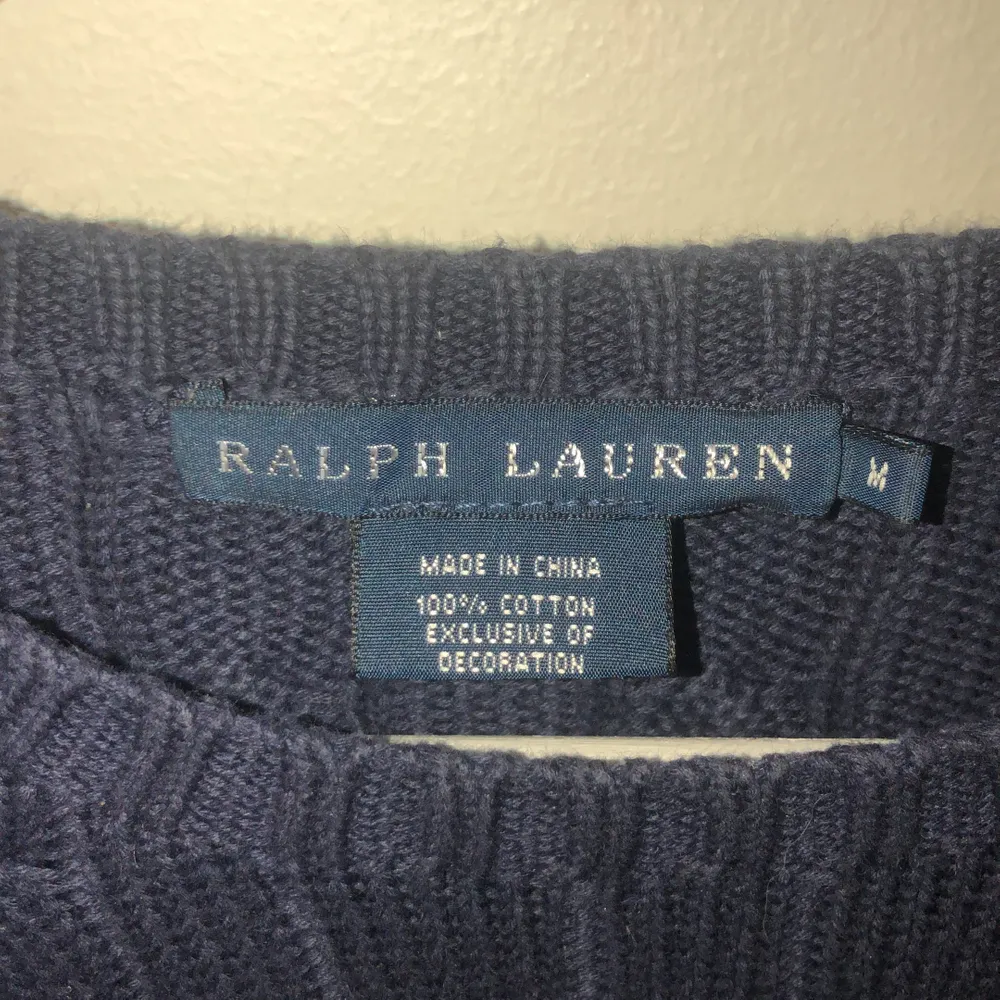 En mörkblå, kabelstickad Ralph Laurens tröja som sitter jättefint på. En skjorta under piffar upp den ännu mer! Är M men sitter som en S.. Stickat.
