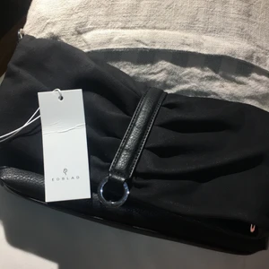 Edblad Hepburn Clutch NY! - Perfekta nyårsväskan!! Helt oanvänt med lapp kvar.               (Inte så glittrig som första bilden visar, hade blixt.) Fick i present men kommer tyvärr inte till användning 💕 suede och faux leather , rymlig med innerficka och krokar för kedja. Hittar ingenstans när jag försökt söka på den så buda!! 
