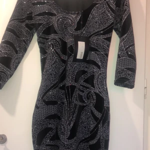 Perfekt nyårsklänning - Storlek XS. Väldigt töjbar. Helt ny med taggen kvar! Kan fraktas eller mötas upp i Stockholm.