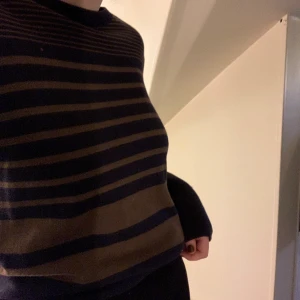 Stickad tröja - Marinblå stickad tröja med bruna ränder. 