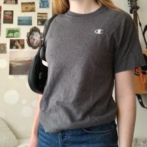 Champion t-shirt  - Grå t-shirt från Champion med broderat märke! Säljer för att den inte kommer till användning🤍 Passar XS-L beroende på hur man vill att den ska sitta, men den är lite oversize på mig som har S. Kan mötas i Göteborg, annars tillkommer frakt :)
