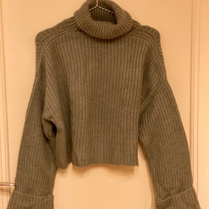 Grön tjocktröja stl. XS - Grön polotröja med utsvängda armar. Lite kortare modell som slutar runt naveln. Priset för frakt tillkommer.