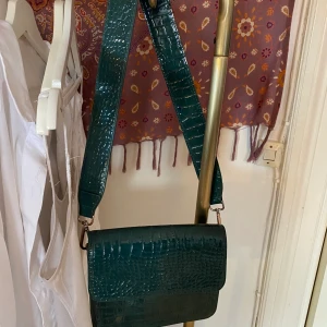 Snygg väska från Hvisk! - Säljer nu min supersnygga hvisk väska som är i ormskinns-imitation i en snygg blå/grön färg! Den är rymlig men absolut inte klumpig. Den är i superbra skick. Frakt står köparen för! 💖