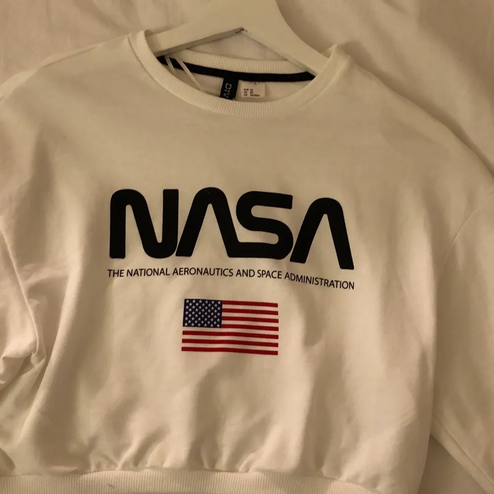 Vit croppad tröja med NASA tryck och svart sträck på armarna. Strl XS. Knappt använd i nyskick. Säljes pga garderobränsning. 50kr+frakt. Tröjor & Koftor.