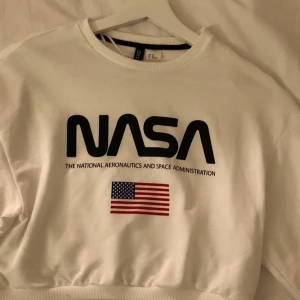 Vit NASA tröja - Vit croppad tröja med NASA tryck och svart sträck på armarna. Strl XS. Knappt använd i nyskick. Säljes pga garderobränsning. 50kr+frakt