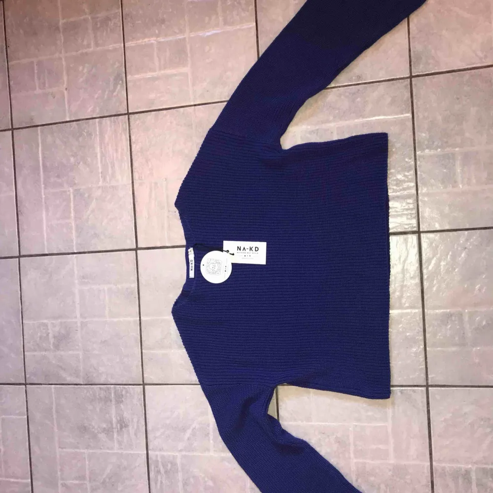 En jättefin blå stickad tröja från NA-KD. Helt oanvänd!! Vida ärmar och lite croppad modell.  Storlek: M  Nypris: 400kr 💙💙💙💙💙💙. Tröjor & Koftor.