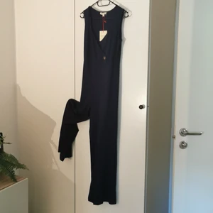 Marinblå byxdress stl M - Snygg byxdress med snygg urringning och smickrande detaljer. Stretchigt material för perfekt passform. Ny. Stl M. Köpt i USA. 