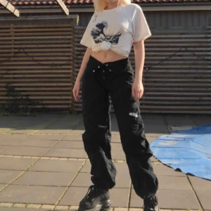 Svarta cargopants - Svarta cargopants i storlek XS, köpta här på plick (förra säljarens bilder) men jag är en S så de var för små på mig! Sjukt coola med dragjedjor och fickor på benen, passar antagligen någon med storlek 32-34