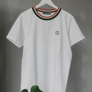 Acne studios tshirt - Snygg, vit T-shirt från acne studios med färgade detaljer. Är tyvärr inte helt 100 på äktheten då den är secondhand, så priset är därefter :)