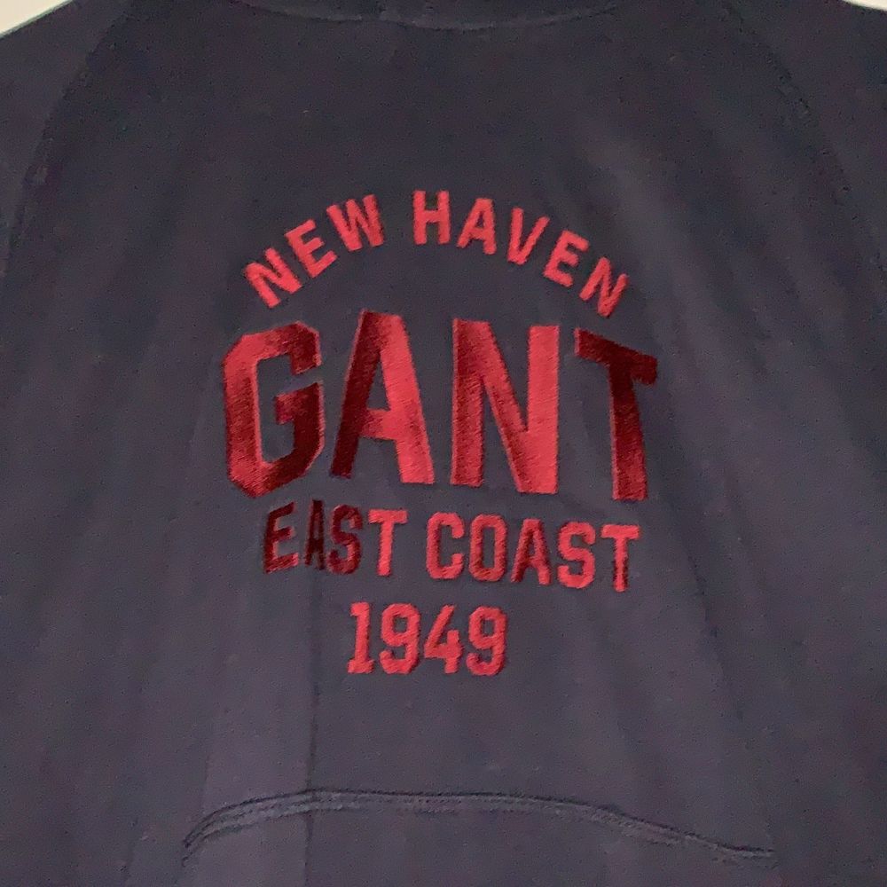 Mörkblå hoodie från Gant med röd text fram och huva bak. Säljes pga att den inte kommer till användning. Använd ca 3 ggr.. Huvtröjor & Träningströjor.