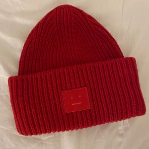 Röd acne mössa - Säljer min gamla acne mössa (äkta), använd få gånger, fint skick! Skriv privat om du är intresserad! 💙 kan mötas up annars står köparen för frakt.