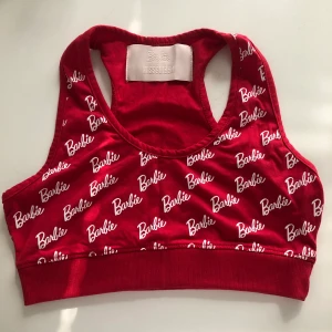 Barbie topp från Missguided storlek 40  - En snygg behå/topp från Missguided x Barbie i röd med Barbie login på, köpt för tre år sedan men aldrig använd. Frakt betalas av köparen. Skriv gärna om du har några frågor✨