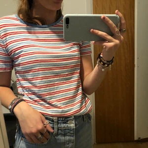 Randig t-shirt - En supergullig randig t-shirt från bikbok. Den är röd, vit och blå randig. Är i storlek M men är rätt liten i storlek. Säljer för 30kr + frakt. 