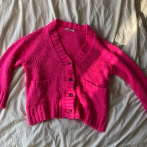 Oversize stickad kofta från NA-KD - Skrikrosa stickad kofta från NA-KD som är i storlek XS men är oversize, knappt använd.