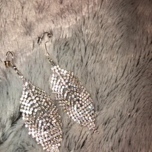 Örhängen - Snygga festliga Örhängen i silver. Köpta till balen men kom aldrig till användning så de är oanvända. Köpta för ca 150kr.