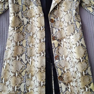 Kappa från NA-KD, ormskinnsmönstrad - Säljer min i princip oanvända kappa från NA-KD. Samma kappa som Therese Lindgren fick av Lisa Anckarman. Tyvärr är kappan lite fel storlek för mig och därför säljer jag den (för att köpa en ny). strl 36 (small)