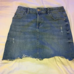 Blå jeans kjol - Blå jeans kjol i bra skick! Slitningar längst ned på kjolen.