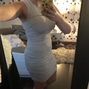 Grå klänning - Grå superfin klänning med offshoulder på ena sidan. Använd ett fåtal gånger men är lite liten nu. Storlek S. Frakten ingår i priset!