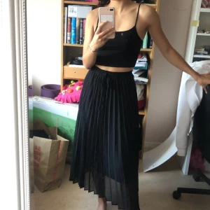 Plisserad lång kjol - Lång svart kjol som har två tyg, ett svart undertyg och ett svart övertyg som är genomskinligt. Övertyget är också lite längre än undertyget. Jag är 166 cm lång. 💕Köparen står för frakt. Den är stretchig i midjan därför passar den flera storlekar.