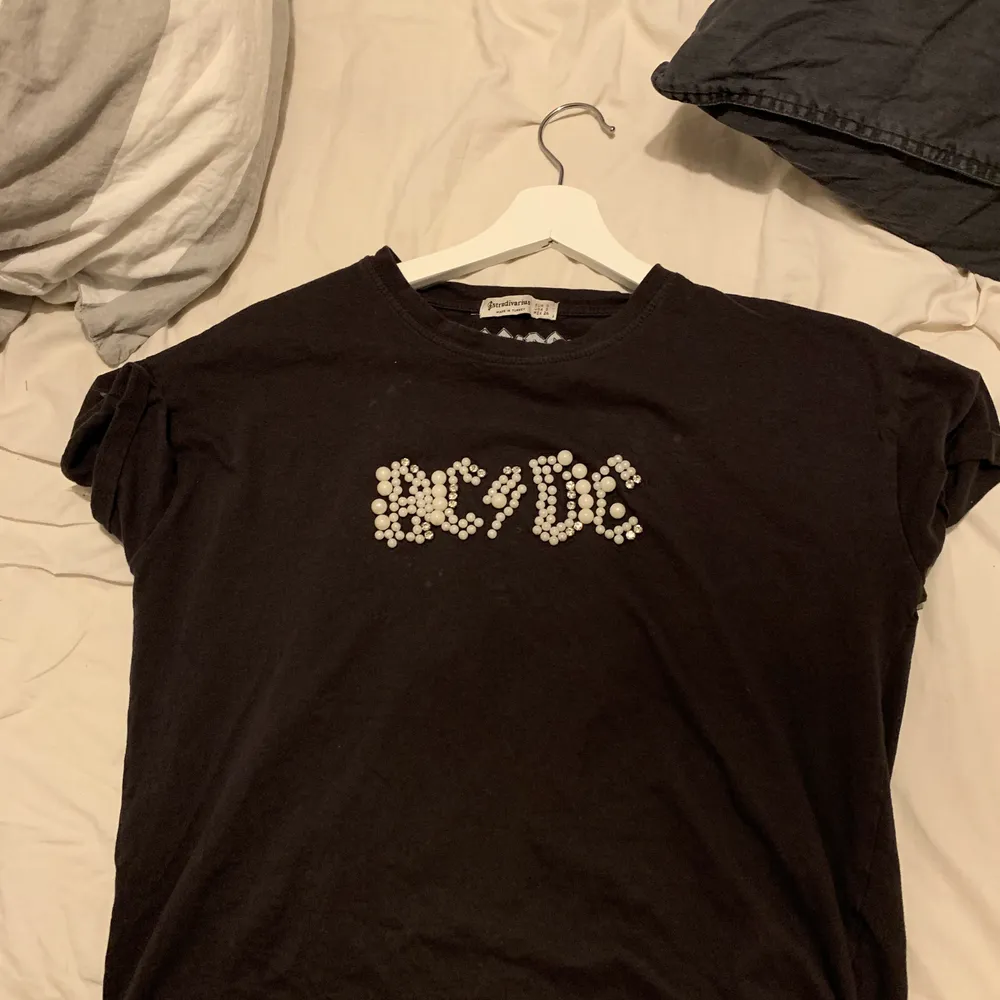 SUPER SNYGG t shirt, acdc tryck med pärlor! Älskar denna tröja har tyvärr växt ut den! Köpte den i Spanien på stradivarius sommaren 2019, har använts tröjan snällt så den är så gott som ny, köpt för 400, fläckarna som man ser på 2a bilden syns inte irl!! . T-shirts.