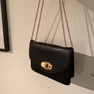 Axelväska  - Perfekt svart liten axelväska. Vet ej märket då det varit en present. Skriv för fler bilder💓