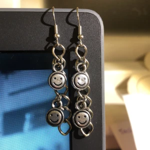 örhängen!!  - silvriga örhängen med en kejda och smileys!! egengjorda av mig, två par finns. frakt tillkommer med 11kr💞