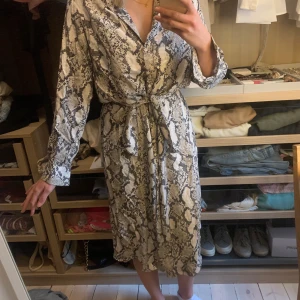 Klänning från H&M  - Jätte fin klänning i ormmönster, storlek 38. Använd en gång så är iprincip oanvänd. Säljer då den inte kommer till användning. Pris 250kr exklusive frakt.