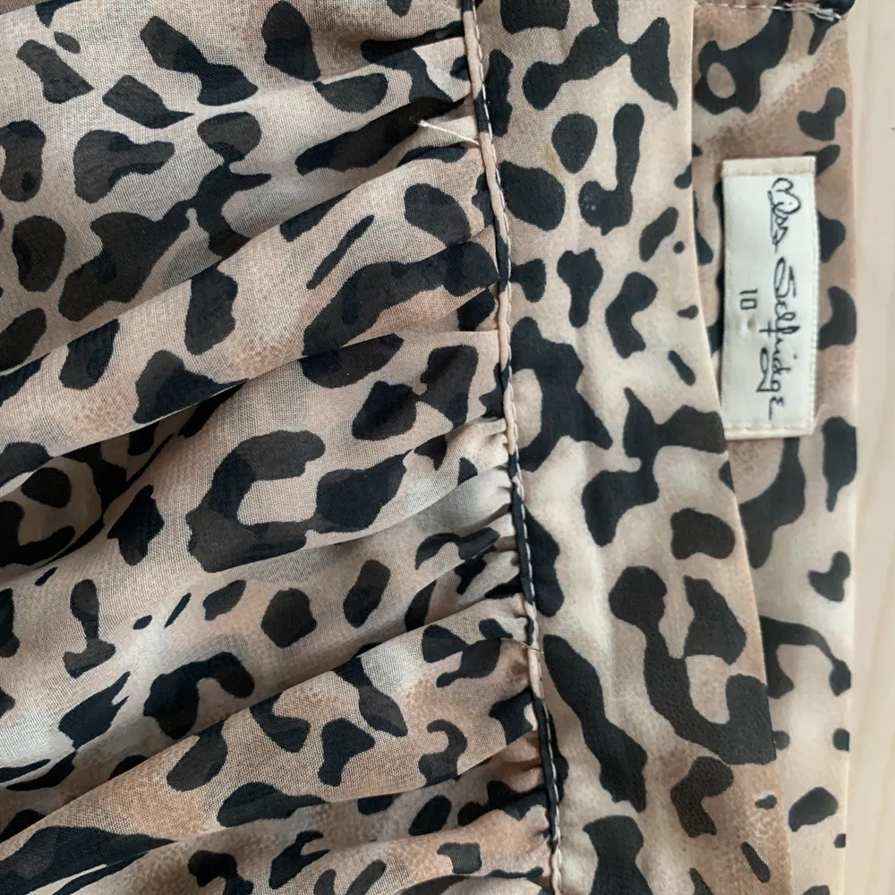 Lång kjol från Miss Selfridge i leopardmönstrad. Den har en underkjol (så den inte är genomskinlig), lagerna över ligger omlott och den är skuren/kortare på vänstersidan. Dragkedja på sidan, väldigt fint häng. Använd ett fåtal gånger så är i nyskick :) återkom om ni vill ha fler detaljer 🤗. Kjolar.