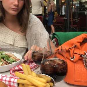 Väska från sandro - Snygg orange väska från sandro. Sparsamt använd. Har gjort två hål i det långa väskbandet för att kunna ha den kortare