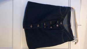 Highwaistad jeanskjol från Monki i mörkblå färg. 