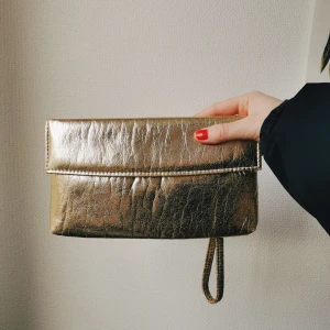 Guldig clutch  - Vintage clutch i guldfärg. Inte använd av mig, men köpt på vintageaffär. Perfekt till festen✨✨ 