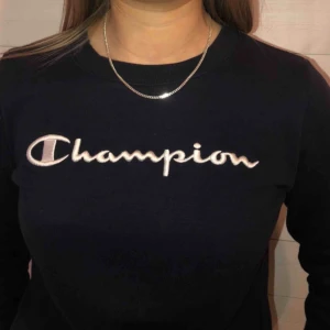  - Populär tröja från Champion med ett märke på bröstet. Vid ärmen är det ett mindre champion märke, en snygg detalj. Tröjan funkar till alla tillfällen och passar perfekt till jeans. 