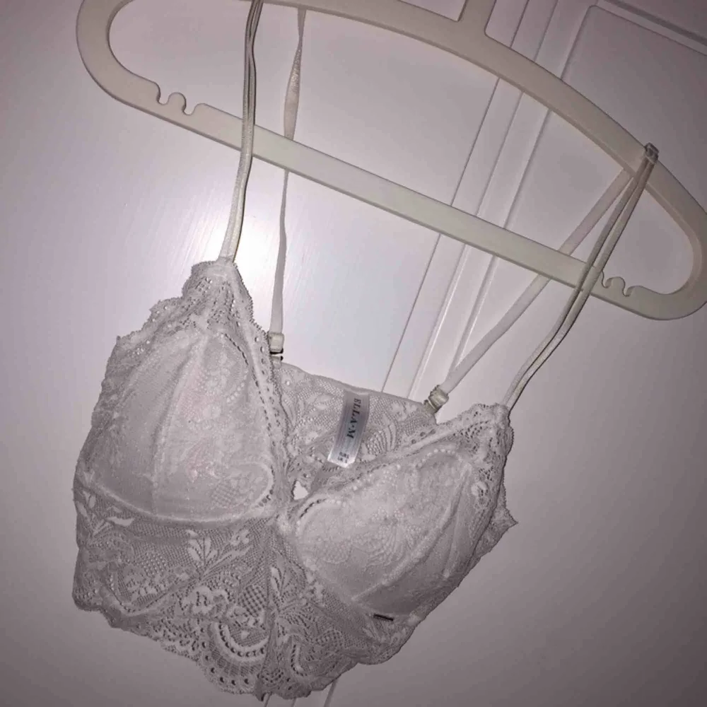 Väldigt fin vit bralette/spetstopp med ilägg från Ella M, storlek S men fungerar nog som XS också då den är ganska liten i storleken. Justerbara band. Använd fåtal gånger, säljes för att den är för liten för mig. Bra skick. Köparen betalar för frakt. Toppar.