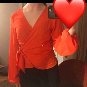  - En röd blus som man knyter på sidan, aldrig använd och har kvar prislappen. 200kr inklusive frakt. 