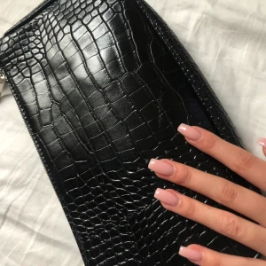 Svart baguettväska krokodilmönster - Säljer denna superfina svarta väskan från Shien, helt ny, toppskick plasten på axelremsan är fortfarande kvar. Säljer pågrund av att jag hittade en väska jag hellre vill ha. Dm:a vid intresse 🥰 Köparen står för frakten