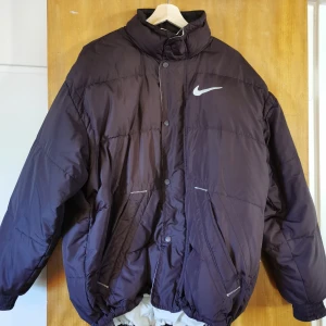 Nike dunjacka  - Tjock dunjacka från Nike, perfekt till vintern. Står storlek 178 men den sitter som en M. Bud under bilden💓Den är svart, men var svårt att få med på bild 