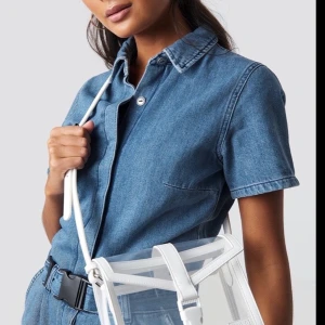NA-KD transparent crossbody bag - Säljer min otroliga NA-KD transparent crossbody bag OBS min är rosa! Slutsåld på hemsidan. Mycket sparsamt använd! Rymlig med justerbar axelrem. Skriv bara om du verkligen tänker köpa! 
