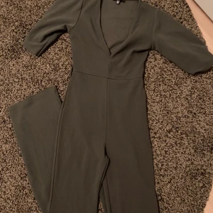 Byxdress - Lång byxdress i grön. Jag är 170 cm lång och den sitter perfekt i längd.  Använd endast vid 1 tillfälle. Skärp saknas.