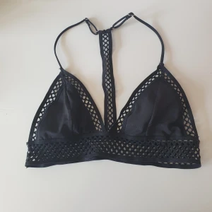 Svart Bikiniöverdel - Bikiniöverdel med unik design i ryggen från H&M. Storlek S, men passar även XS. Använd sparsamt, så i gott skick. Köparen betalar frakt.