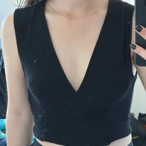 Svart topp med djup urringning  - Svart topp från Zara med knytning bak.