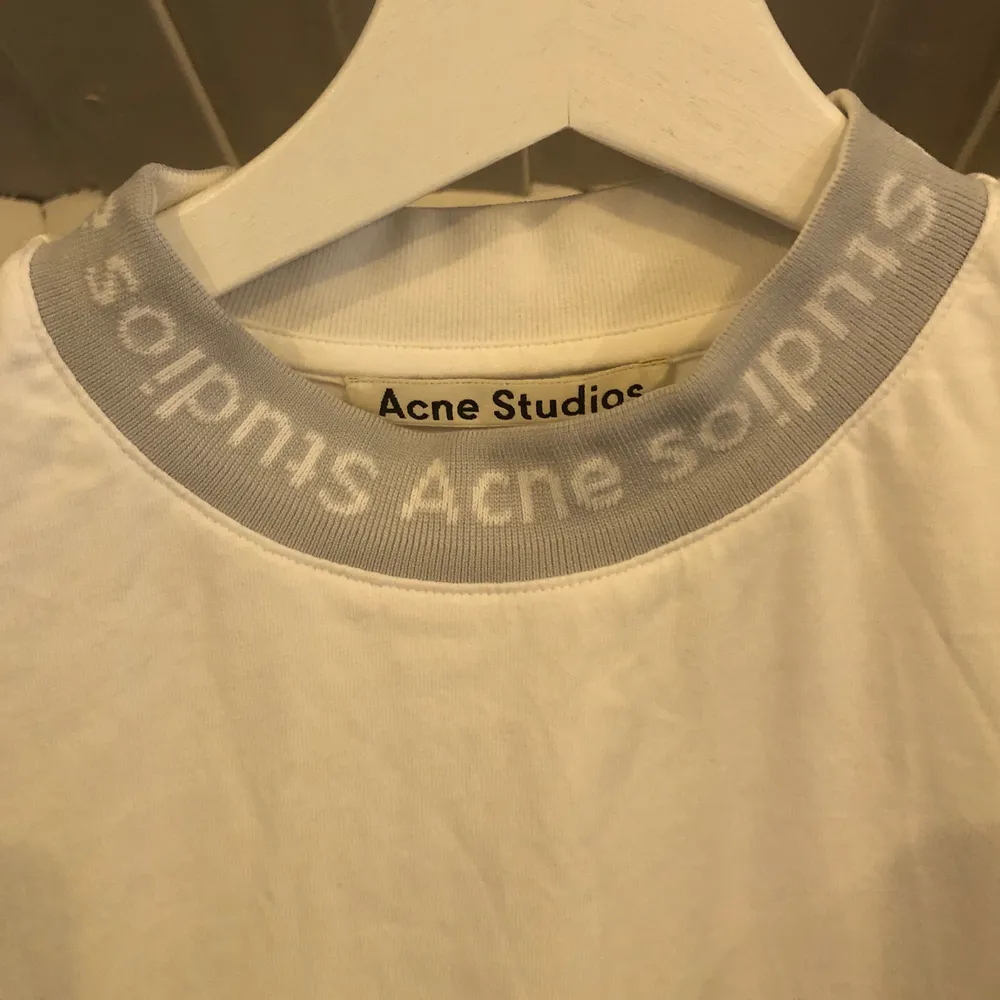 Supersnygg och cool tshirt från Acne. Den är sparsamt använd och i nyskick! Den är vit med ljusgrå/vit krage. I storlek XS, men passar mig som har s/m. Inköpt på NK i Stockholm.. T-shirts.