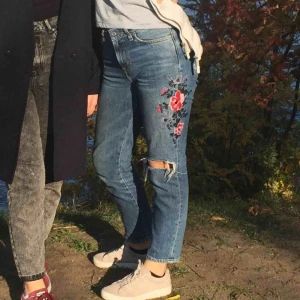  - (Gamla bilder!) Säljer mina favorit-jeans pga för små. De passar strl 34-36. Blåa jeans med broderade blommor och hål på knät. Använda mycket men är i gott skick! Kan mötas upp eller frakta, köparen står för frakt✨🦋