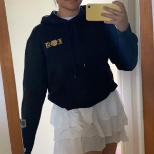 Svart hoodie med broderad detalj - Svart jättemysig hoodie från HM med LA-tryck. Använd men i felfritt skick! Säljer då jag redan har alldeles för mycket hoodies 💛💛 frakt ingår i priset!