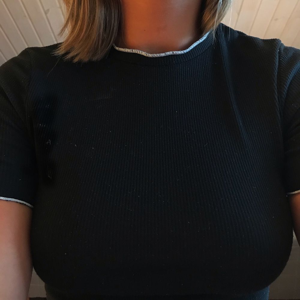 En svart ribbad croptop t-shirt ifrån Zara i storlek S. Den har små vitavolanger längst ut och är väldigt stretchig. (Pris är exkl. frakt)⭐️ för paketpris - skriv dm💓. T-shirts.
