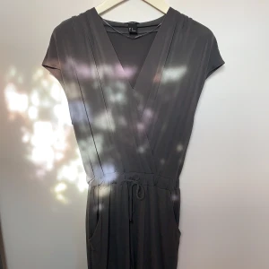 Byxdress från Lindex  - Superskön(!!) byxdress från Lindex i storlek 36. Resår med knyte i midjan, knapp vid bröst, fickor både fram- och baktill samt upprullade byxben på bild som går att rulla ner. Inga anmärkningar! 